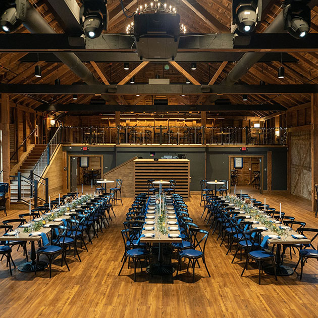A large room with tables and chairs set up in a barn, perfect for hosting Pennsylvania bridal shows or Pennsylvania wedding expos.