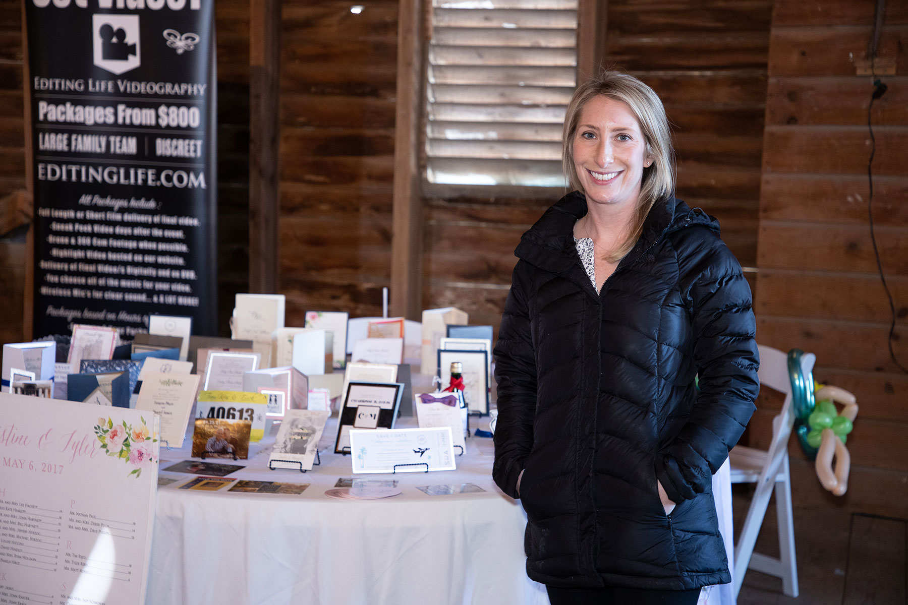 A woman standing in front of a table full of cards at a Pennsylvania wedding expo.