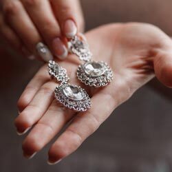 A woman's hand elegantly displaying a pair of earrings at the Pennsylvania Bridal Shows.