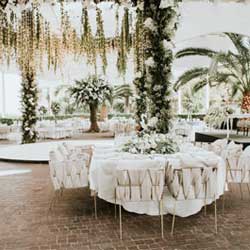 A stylish wedding reception set up with white tables and chairs at a Pennsylvania bridal show.