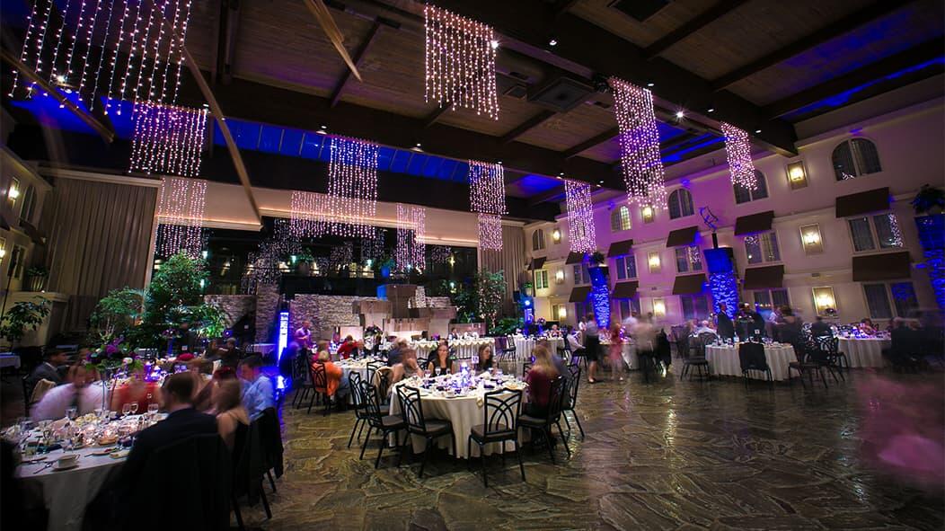 The grand hall, set for the York Wedding Expo, features elegantly arranged tables ready for dining, beneath a ceiling adorned with cascading lights.